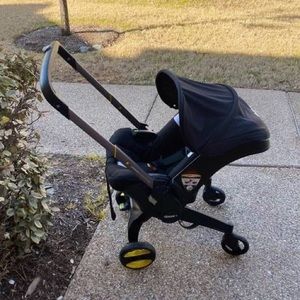 Selling my Doona stroller. Comes with black doona bag & a pink cover .